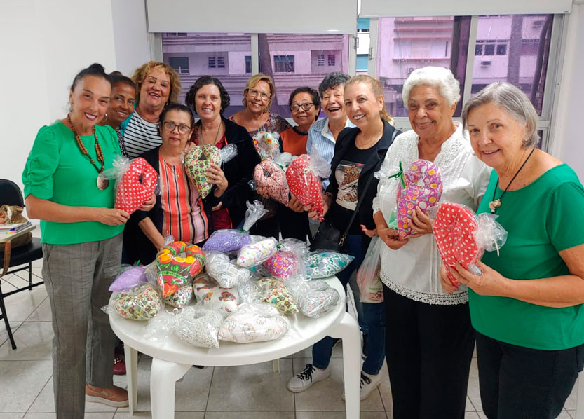 Grupo de senhoras segurando almofadas em formato de Y